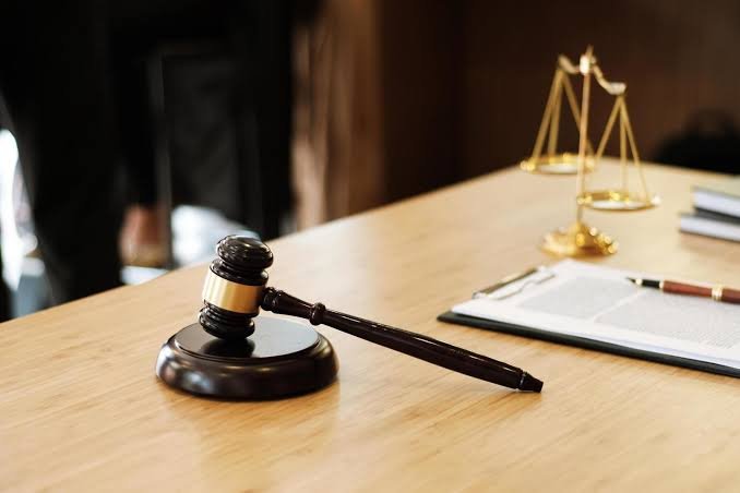 Martelo de juiz e balança da Justiça sobre mesa de trabalho
